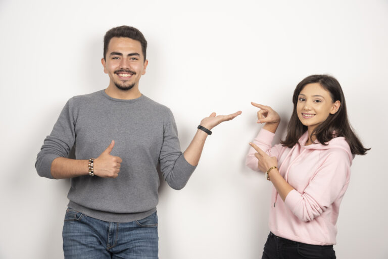 Young couple pointing at themselves on white background. High quality photo